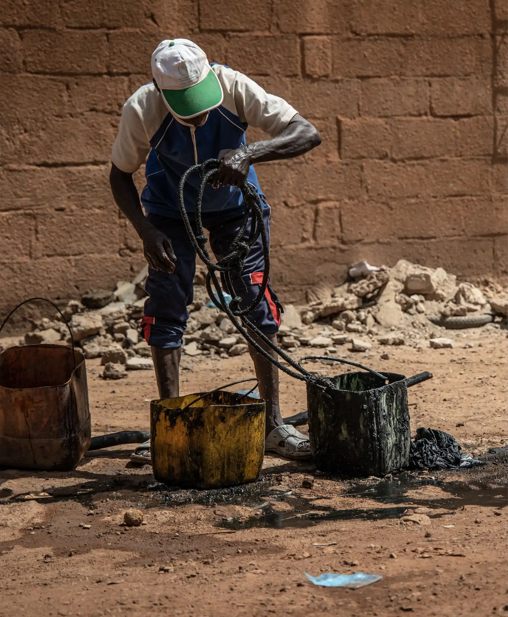 A man in Ouagadougou, Burkina Faso, manually emptying a family’s latrine.