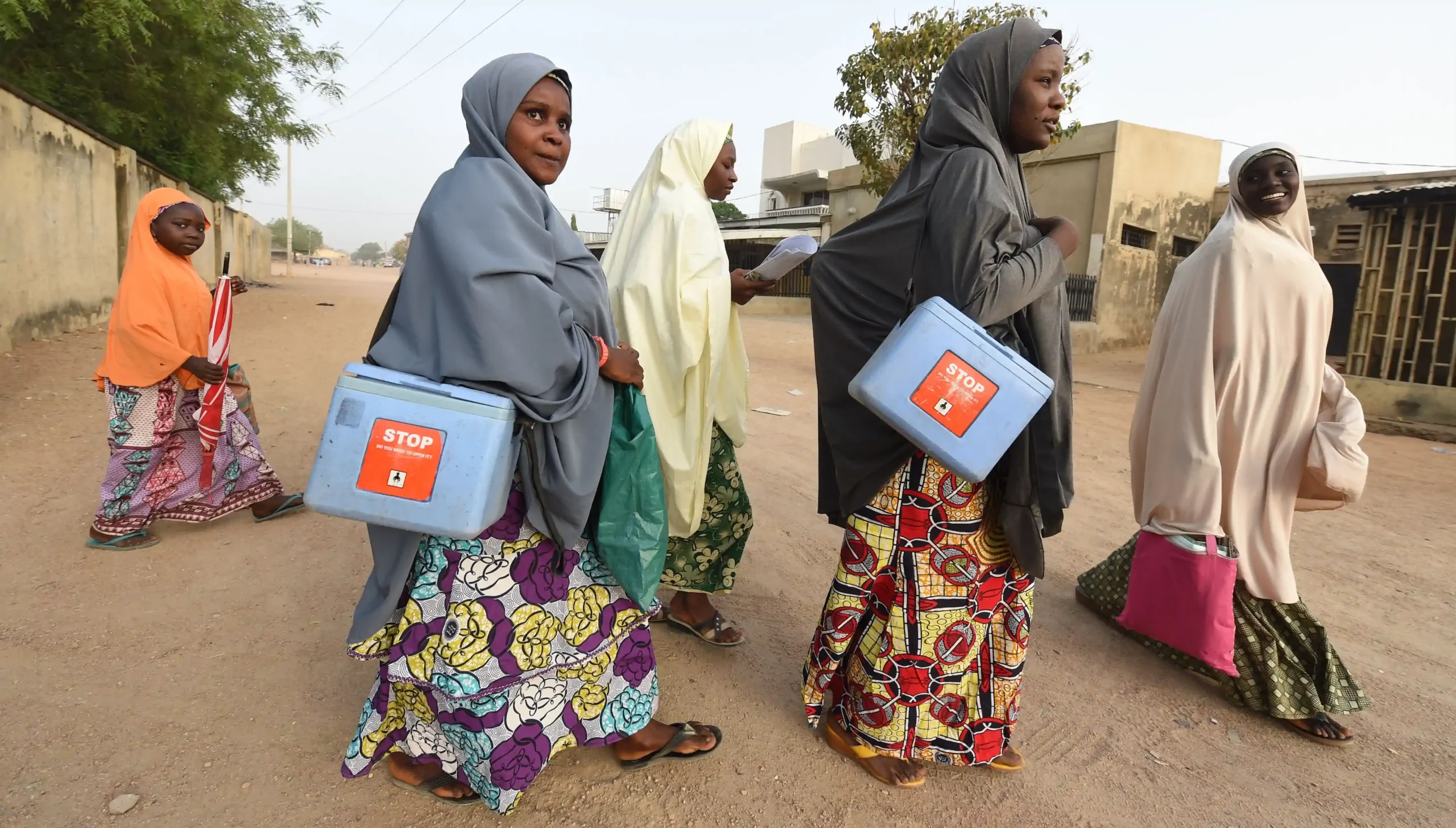 Health workers going door-to-door during a child immunization campaign against polio in Nigeria