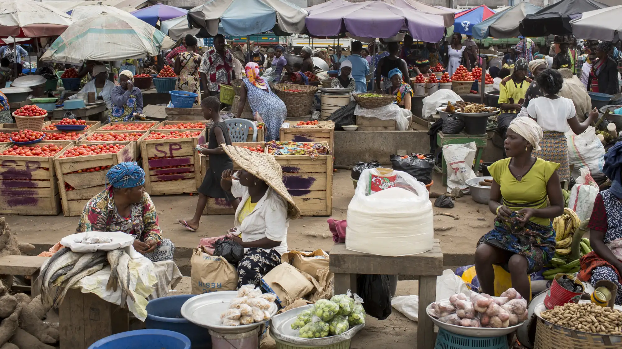 A busy market with stalls of fruit and vegetables